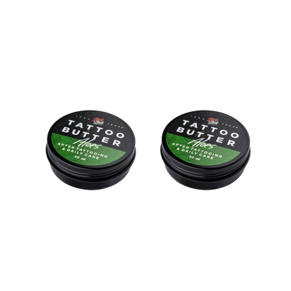 Two tins of Love Ink Tattoo Butter on a transparent background. Both tins are labeled 'Tattoo Butter Aloes' with an green design