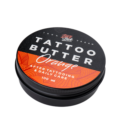Close-up of a jar of Tattoo Butter Orange by LoveInk. The sleek black and orange packaging highlights its purpose for after tattooing and daily care, 100ml size.