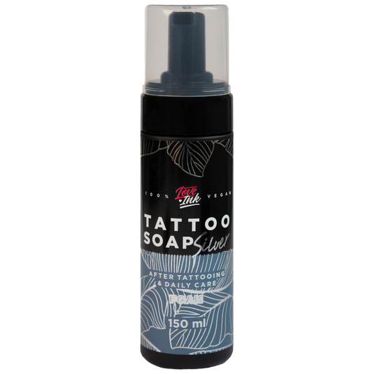 Image of LoveInk's Tattoo Soap Silver bottle containing 150ml of foam for tattoo care. The black bottle features white and silver botanical designs with a clear cap.